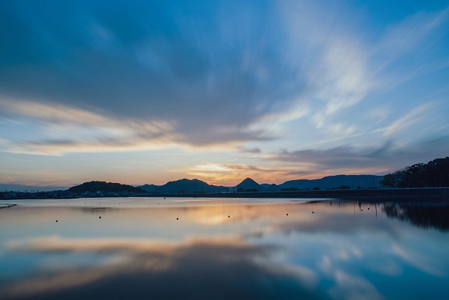 空の夕日と、その夕日が海に映し出された様子